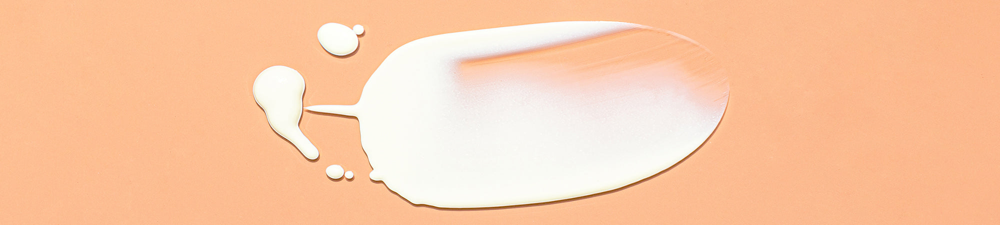 KG essential spf swatch on a tan background